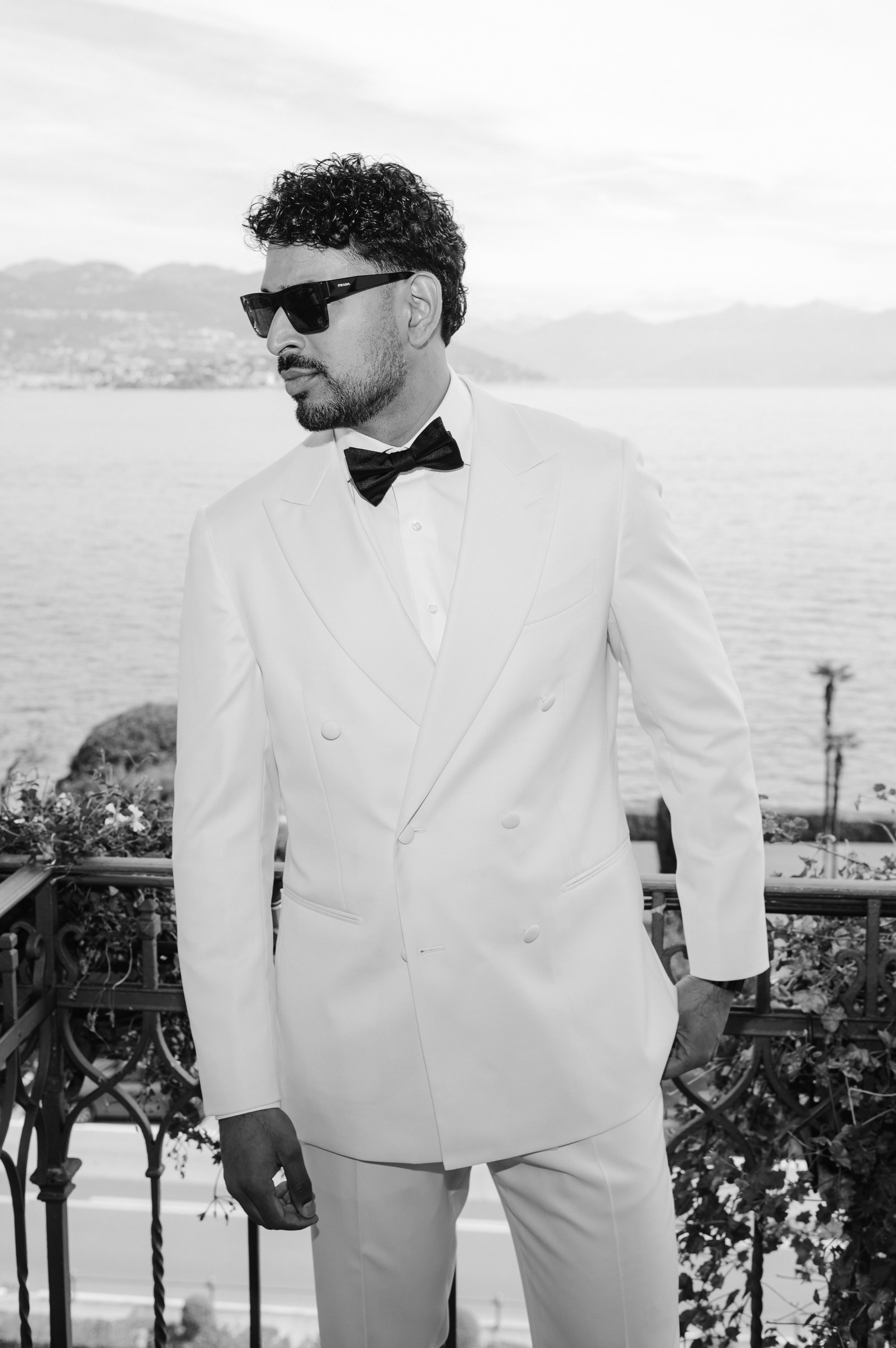 Elegant Groom at Lake Maggiore Wedding Groom wearing an elegant ivory wedding suit and black bow tie overlooking Lake Maggiore.