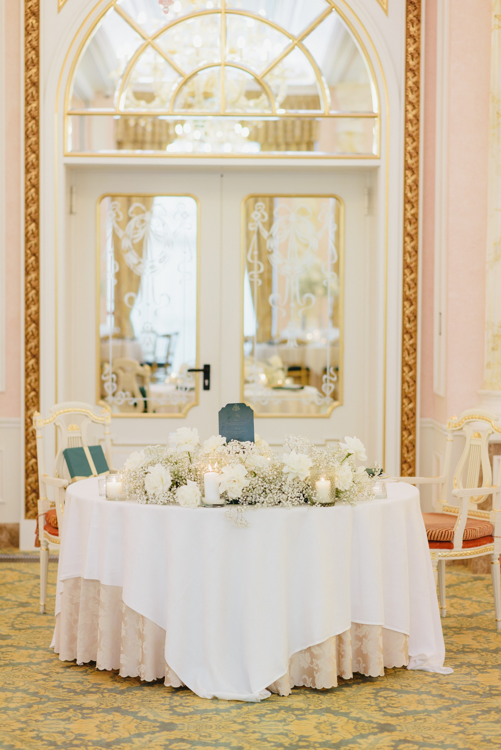 Luxury Wedding Table Decoration – Lake Maggiore Elegant wedding table with white floral centrepiece, gold chairs and candlelight at Grand Hotel des Iles Borromées.