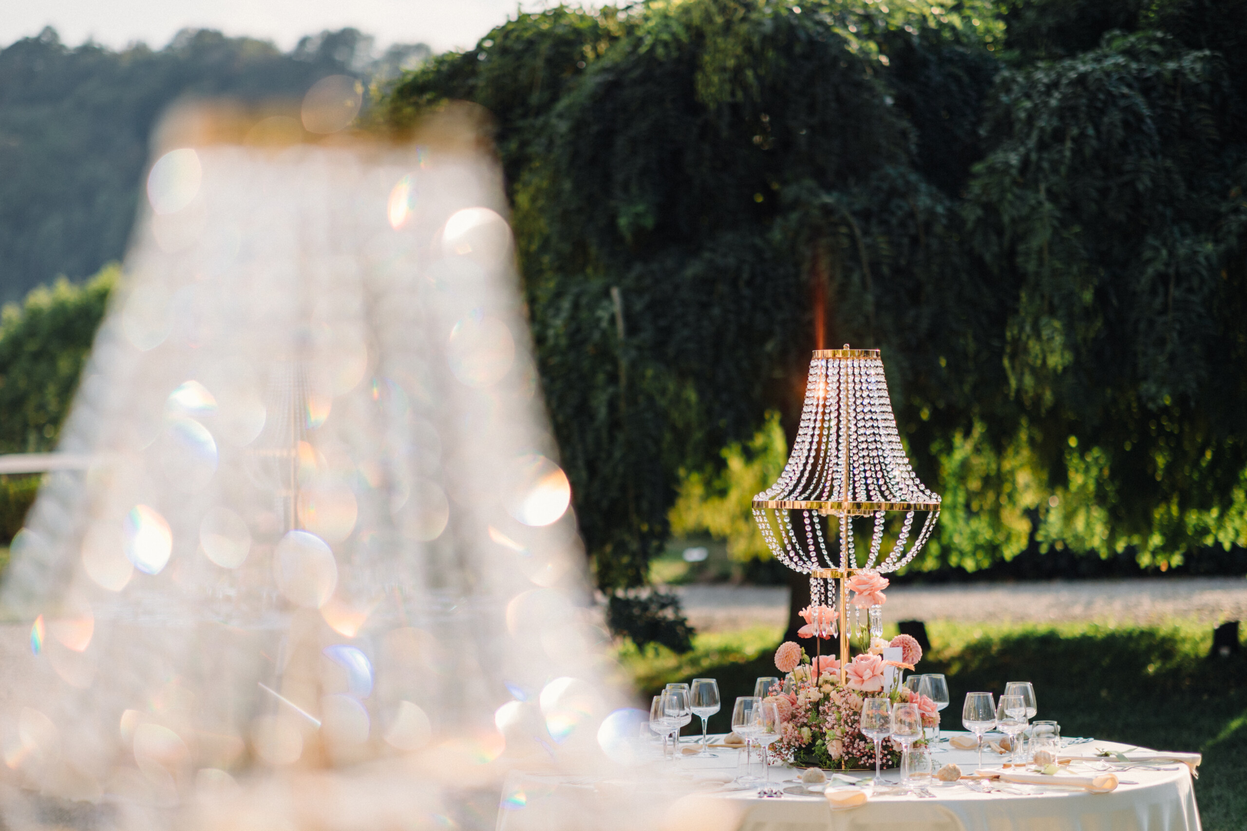 Elegant Wedding Decorations at Villa Cimena Decorative lamp with hanging crystal beads and pink flowers at the outdoor wedding reception at Villa Cimena.