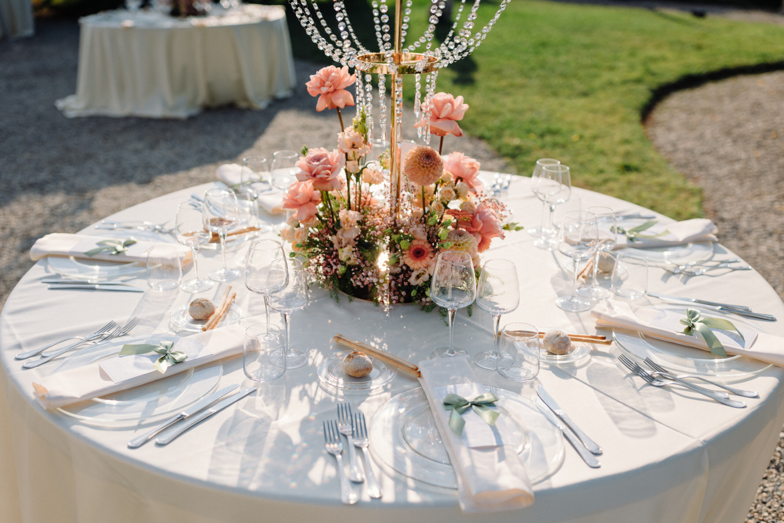 Pink and Peach Wedding Centerpiece – Villa Cimena Wedding table centerpiece with pink and peach flowers, candles and elegant white table settings at Villa Cimena.