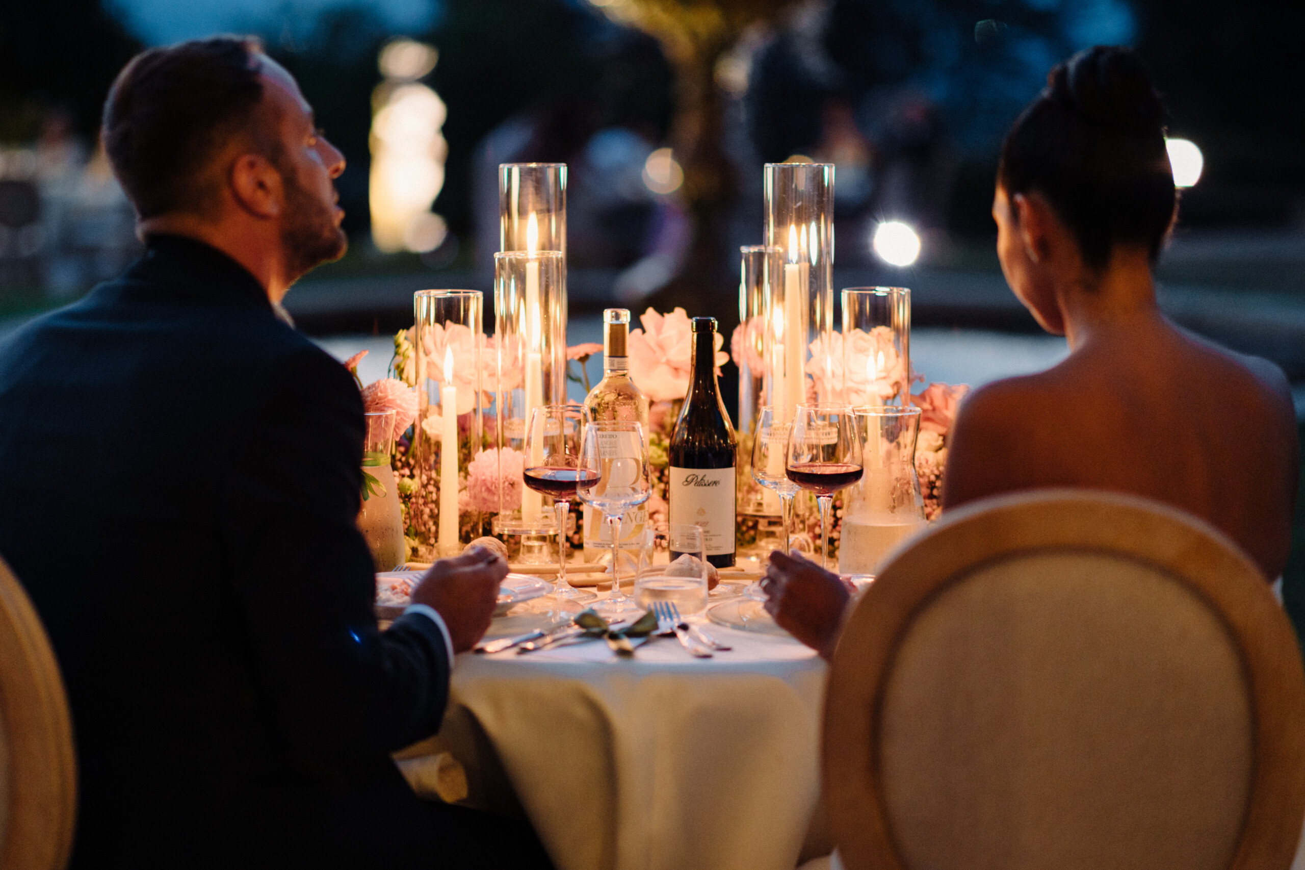 Elegant Wedding Dinner at Villa Cimena – Turin Groom and bride seated at an elegant dinner table with candles and floral arrangements at Villa Cimena in Turin.