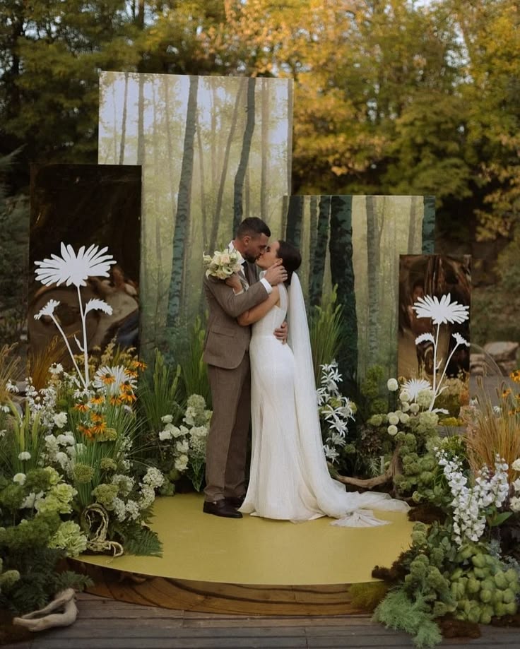 Bride and groom embracing in front of an artistic mirrored wedding ceremony backdrop surrounded by flowers