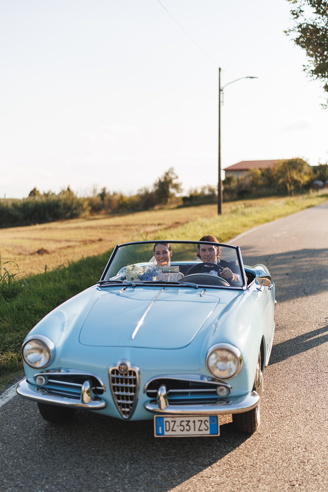 Auto d’epoca matrimonio – Gina e Christian Gina e Christian su Alfa Romeo Spider azzurra d'epoca dopo il matrimonio